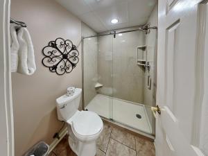 une salle de bain avec toilettes et douche en verre dans l'établissement Smoky Mountain Bliss Whispering Pines 323, à Pigeon Forge