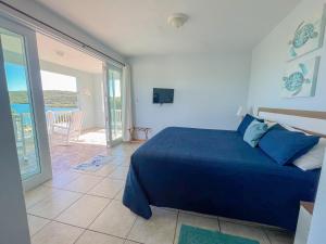 a bedroom with a blue bed and a balcony at Island Charm Culebra - Studios & Suites - Amazing Water views in Culebra Puerto Rico! in Culebra +72 photos