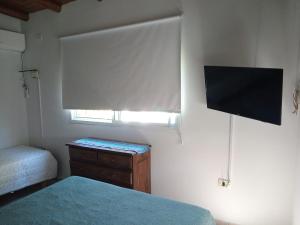 Un dormitorio con una cama y un televisor de pantalla plana. en El Sosiego Posada de Campo, en Colón