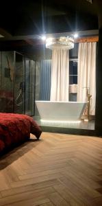 a bathroom with a tub and a bed in a room at Apartament Plac Zabaw in Łódź