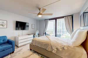 1 dormitorio con cama, TV y sofá azul en Waves & Palms Oasis, en Marco Island 37 fotos más