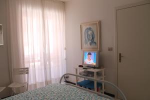 a bedroom with a bed and a tv and a window at Casa Vacanze Mascali in Riposto