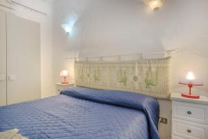 Casa TamponiBurricheddu 1的一间卧室配有一张蓝色的床和两盏灯。