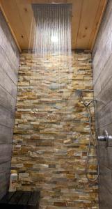 a shower in a bathroom with a stone wall at Black Bear Cove in Gatlinburg +40 photos