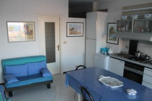 kuchnia z niebieskim stołem i niebieskim krzesłem w obiekcie Casa Vacanze Mascali w mieście Riposto