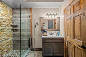 a bathroom with a sink and a glass shower at Smoky's Lodge in Pigeon Forge +23 photos