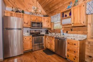 a kitchen with wooden cabinets and a stainless steel refrigerator at Sunset Ridge in Sevierville