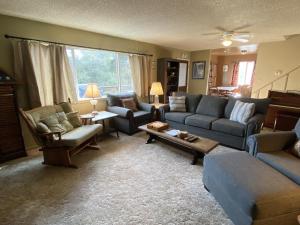a living room with a couch and chairs and a table at Hodges Hill Yosemite House in Oakhurst