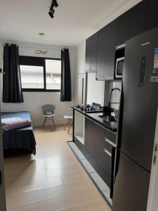 a kitchen with a black refrigerator in a room at 3-Apto Studio Liberdade 450' Metrô -Teatro Renault in Sao Paulo