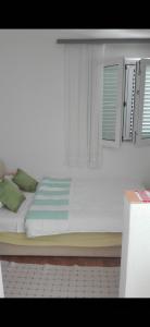 a bedroom with a white bed with a window at Apartments Vesna in Ribarica