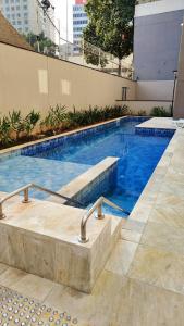 a swimming pool with blue water in a building at 3-Apto Studio Liberdade 450' Metrô -Teatro Renault in Sao Paulo