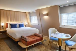 a hotel room with a bed and a table and chairs at master Cannon in London