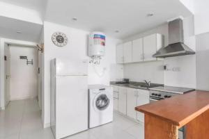 a kitchen with a refrigerator and a washing machine at Alsina 125 in Junín +3 photos