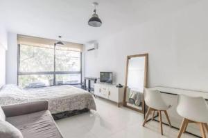 a white bedroom with a bed and a mirror at Alsina 125 in Junín