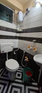 a bathroom with a toilet and a sink at The Hygge Guest House in Kolkata