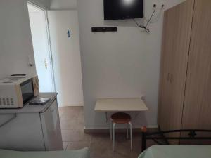 a small kitchen with a desk and a microwave at Filina's Room 1 in Maltezana