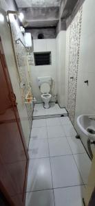 a bathroom with a toilet and a sink at The Hygge Guest House in Kolkata