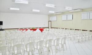an empty room with white chairs and a table at Pousada Central in Feira de Santana