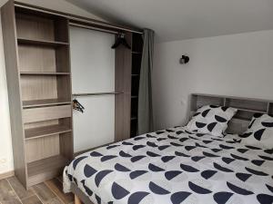 a bedroom with a black and white bed and shelves at La maison du soleil in Pouzauges