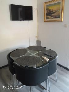 a black table with two chairs and a tv at Apartments Vesna in Ribarica