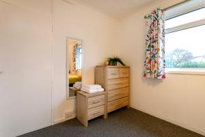 a room with a mirror and a dresser and a window at Cozyhome-3Br-5Guest#netflix#parking#garden in Nottingham