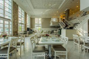 a dining room with tables and chairs and stairs at Charmosos Studios no IL Campanario Villaggio Resort ILCJR II in Florianópolis