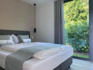 Happynest في زنغست: سرير في غرفة نوم ذات نافذة كبيرة