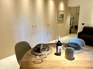 a wooden table with a bottle of wine and glasses at Suite del Pittore in Tivoli +24 photos