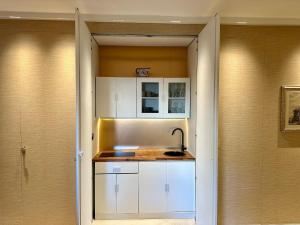 a kitchen with white cabinets and a sink at Suite del Pittore in Tivoli