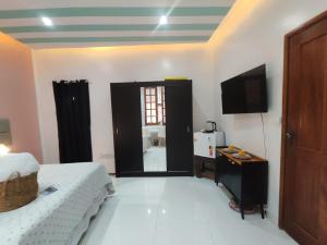a bedroom with a bed and a television in a room at Suíte Paris in Belém