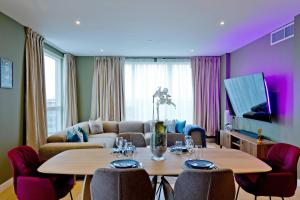 a living room with a table and a couch at Luxury 360 Penthouse with gym & parking in London