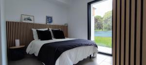 Un dormitorio con una cama y una ventana grande. en Charmante dépendance T3 vue Mer, en Binic