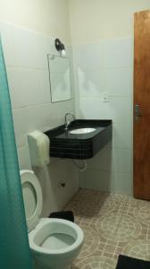 a bathroom with a toilet and a sink at Pousada e Pizzaria Sol e Alegria in Fortaleza