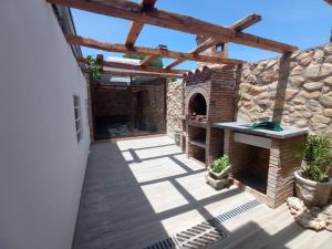 a patio with a stone wall and a pizza oven at La Casa Del Pelao in Solanilla