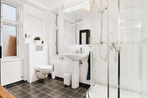 a white bathroom with a toilet and a sink at Dinbnb Home - History meets Modern I 3-Story Bergen House in Bergen