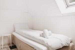 a white room with a bed and a stool at Dinbnb Home - History meets Modern I 3-Story Bergen House in Bergen