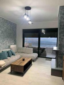 a living room with a couch and a coffee table at Premium Luxury Condo with breathtaking views in Loutraki