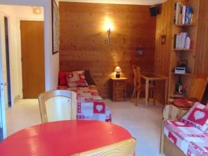 a living room with a red table and chairs and a room with a couch at Studio Chamonix - Animaux Admis, Parking, Balcon - FR-1-517-27 in Chamonix-Mont-Blanc