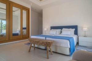 a bedroom with a bed and a bench in it at Crest 5 - 8 Pax Golf & Beach Swimming pool in Almancil +8 photos