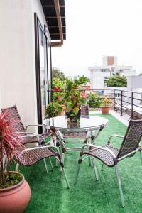 uma mesa e cadeiras numa varanda com plantas em Pousada Cancun em Florianópolis