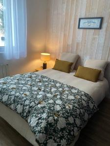une chambre avec un lit avec une couette fleurie dans l'établissement La Maison du Clocher, à Rivedoux-Plage