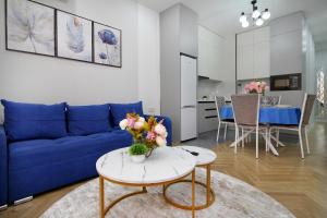 a living room with a blue couch and a table at Central Light Apartment in Almaty