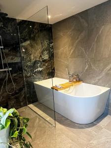 un bagno con vasca bianca e pareti in marmo di Guesthouse Oeyenbos a Knegsel Altre 14 foto