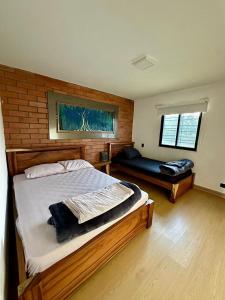 a bedroom with a large bed and a couch in it at Finca Amatista in Guarne +22 photos