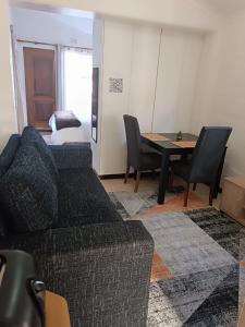 a living room with a couch and a table and a bed at The Berna in Cape Town