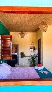 a bedroom with a large bed with purple sheets at Pousada Azul Blue in Amontada