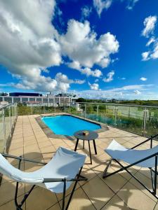a patio with two chairs and a table and a pool at Rooftop Grand-Baie with private pool Ôfwewe in Grand Baie