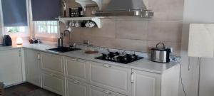 a kitchen with white cabinets and a stove top oven at Spacious House in Calafell with Shared Pool in Calafell