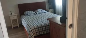 a bedroom with a bed with a checkered blanket and pillows at Spacious House in Calafell with Shared Pool in Calafell