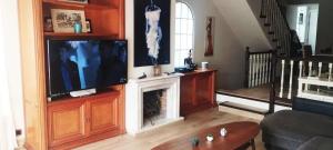 sala de estar con TV y chimenea en Spacious House in Calafell with Shared Pool, en Calafell